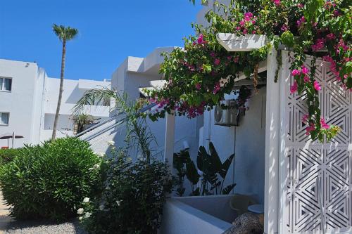 a white fence with flowers hanging from it at Aegean View Hotel in Sfakaki
