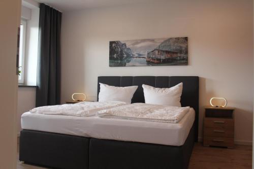 a bedroom with a bed with a black headboard at FeWo-Salzfurtkapelle in Zörbig