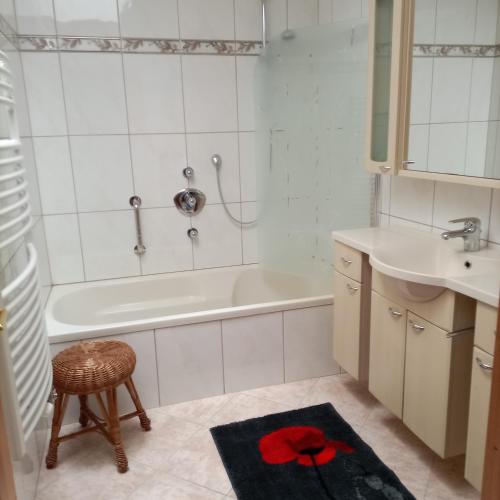 a bathroom with a white tub and a sink at Ferienwohnung am Wirtlerhof in Wildermieming