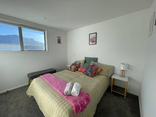 a bedroom with a bed with two towels on it at CBD 2 Bedroom Parkside Living By Hagley with Free Parking in Christchurch