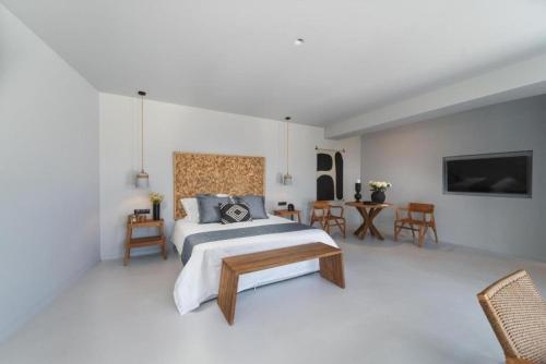 a bedroom with a bed and a table and chairs at Cavalier Suites Nikiana Lefkada AV Properties in Nikiana