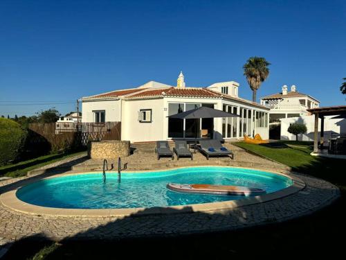 a swimming pool in front of a house at Villa MariSol Ferragudo by Rosado in Ferragudo