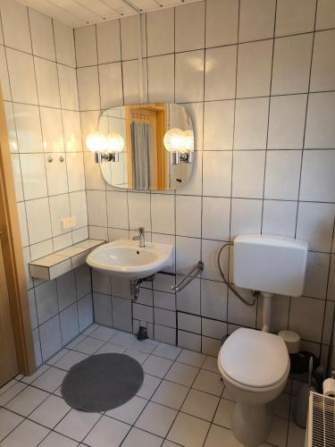 a bathroom with a toilet and a sink at Haus Bahlo - Ferienwohnungen in Attendorn
