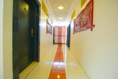 a hallway with a long corridor with black doors at Hotel Upasana in Rajkot
