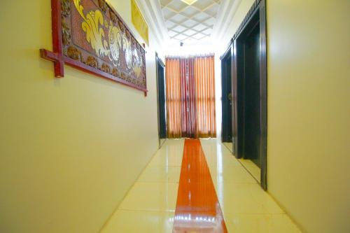 a hallway with a long orange corridor at Hotel Upasana in Rajkot