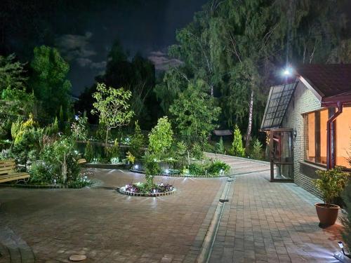 a garden at night with trees and a building at Апартаменти-студіо в Трускавці in Truskavets