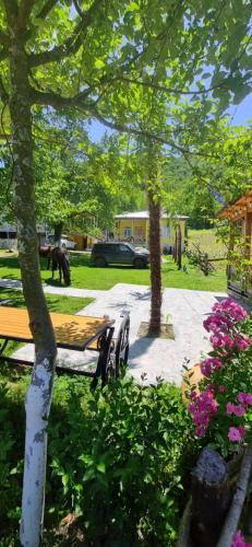 a picnic table and chairs in a park with flowers at Guest House Balda in Martvili