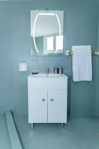 a bathroom with a white sink and a mirror at Sotiria's House in Lakkíon