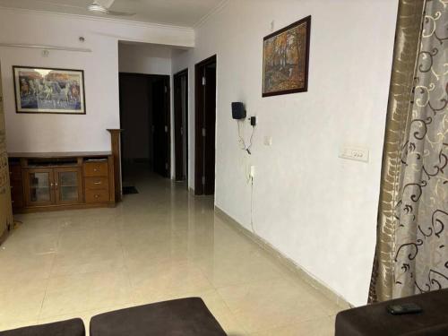 a living room with white walls and a white tile floor at Homestay-a better living in Lucknow