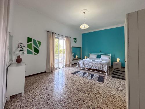 a bedroom with a bed and a blue wall at Sotiria's House in Lakkíon