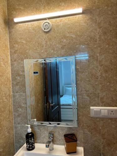 a mirror over a sink in a bathroom at Homestay-a better living in Lucknow