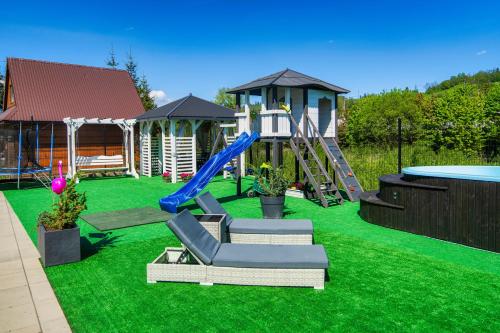 a backyard with a playground with a slide at GORSKI RESORT Lux Apartments Jacuzzi & Sauna in Poronin
