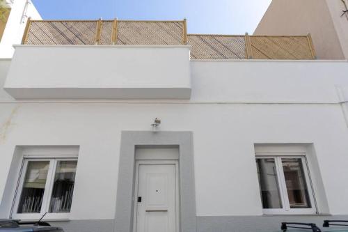 un edificio blanco con una puerta y dos ventanas en Luxury detached house with astonishing roof garden en Athens