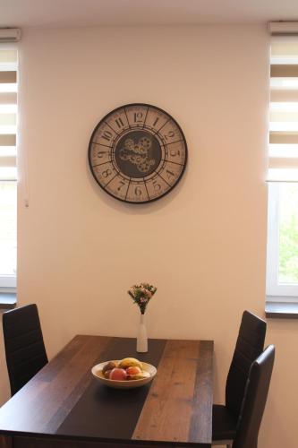 a dining room table with a clock on the wall at FeWo-Salzfurtkapelle in Zörbig