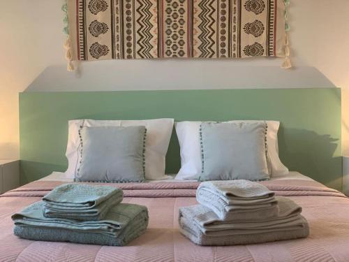 a bed with a pile of towels on top of it at Villa MariSol Ferragudo by Rosado in Ferragudo