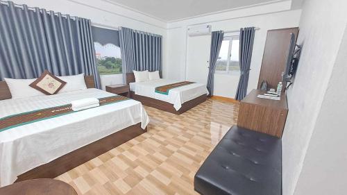 a hotel room with two beds and a television at Family Transit Hotel Nội Bài in Hanoi