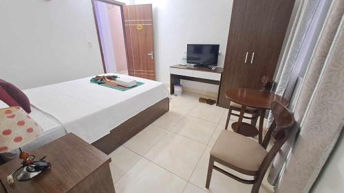 a small room with a bed and a table and a chair at Family Transit Hotel Nội Bài in Hanoi
