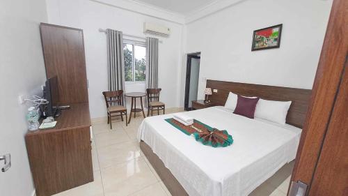 a bedroom with a bed and a table and chairs at Family Transit Hotel Nội Bài in Hanoi