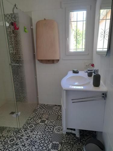 une salle de bain blanche avec un lavabo et une douche dans l'établissement Le Lot pour tous les repos, à Crayssac