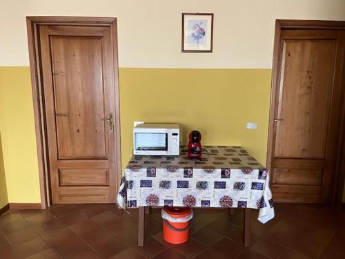 a kitchen with a table with a microwave on it at Foresto Case Vacanza in Volta Mantovana