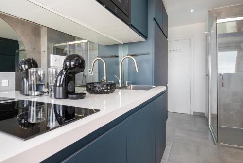 une cuisine avec des armoires bleues et un évier dans l'établissement Village Naturiste R4N - Vida Loca Port Nature, au Cap d'Agde