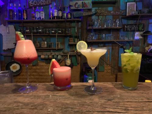 four cocktails sitting on a table in a bar at Seree Bungalows & Chill Bar in Ko Chang