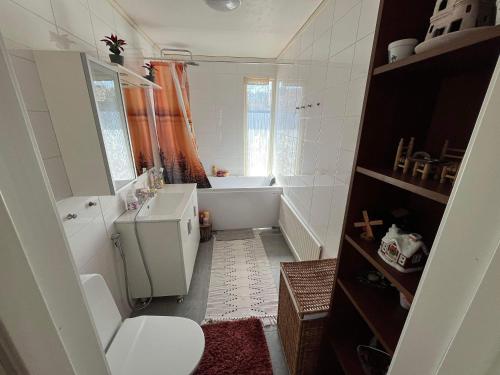 a bathroom with a tub and a toilet and a sink at Slottshuset in Borgholm