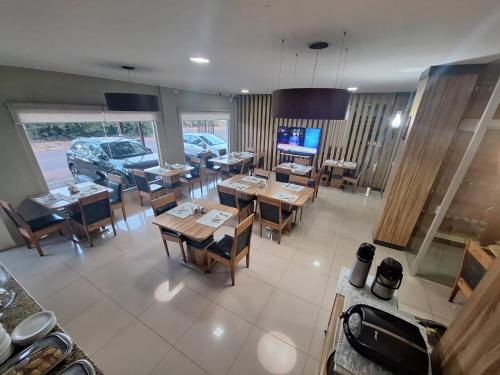 a dining room with tables and chairs in a restaurant at Tacuru Hotel Boutique in Salto del Guairá