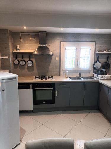 une cuisine avec un évier et une cuisinière four supérieur dans l'établissement Appartement f3, à Cormeilles-en-Parisis