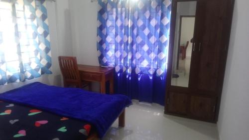 a room with a bed and a table and a mirror at CITY APARTMENTS in Guruvāyūr