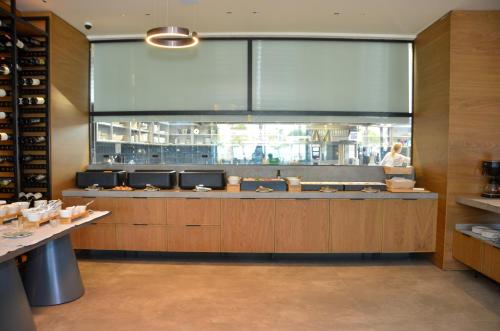 a kitchen with a large window in a restaurant at Abi's Hotel & SPA Vlore in Vlorë
