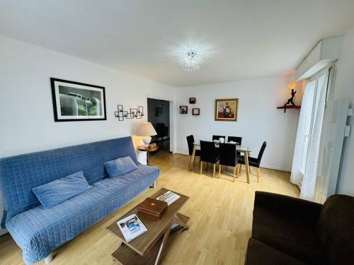 un salon avec un canapé bleu et une table dans l'établissement 3 pièces centre ville, 400m plage, wifi, à Quiberon