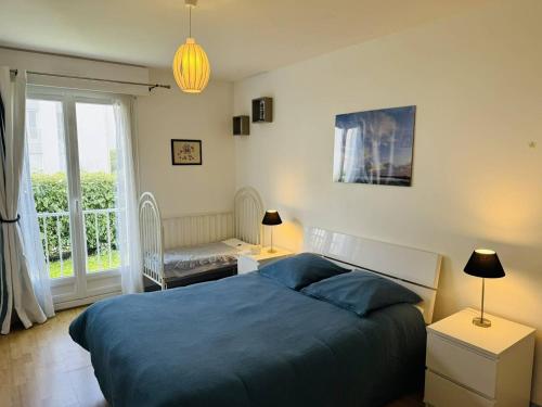 une chambre avec un lit bleu et une fenêtre dans l'établissement 3 pièces centre ville, 400m plage, wifi, à Quiberon