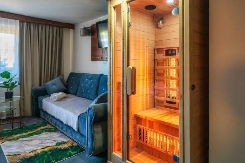 a living room with a couch and a shower at GORSKI RESORT Lux Apartments Jacuzzi & Sauna in Poronin