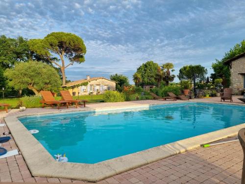 une grande piscine avec de l'eau bleue dans une cour dans l'établissement LBCA maison campagnarde, à Casteljaloux