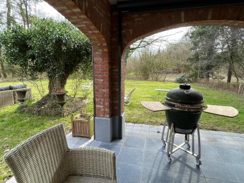 a grill on a patio with a table and chairs at oh deer in Aalter