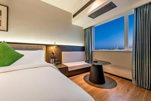 a hotel room with a bed and a window at Xi'an Firefly Hotel in Xi'an