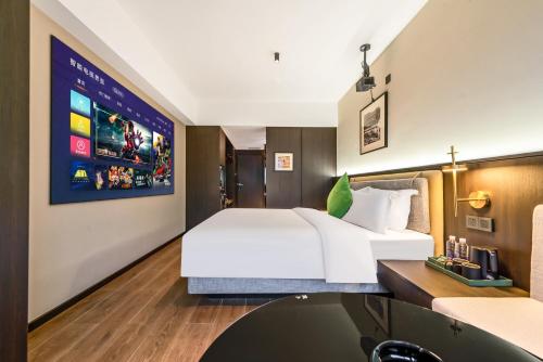 a hotel room with a large bed and a tv at Xi'an Firefly Hotel in Xi'an