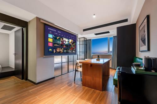a hotel room with a desk and a flat screen tv at Xi'an Firefly Hotel in Xi'an