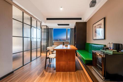 a hotel room with a green couch and a table at Xi'an Firefly Hotel in Xi'an