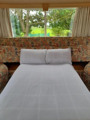 a large white bed in a room with a window at Tir Beag Eile in Ennis