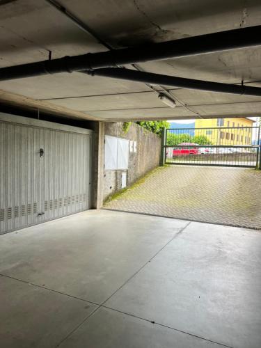 an empty parking lot with a garage with a fence at A DREAM ON THE LAKE Via Roma in Lierna
