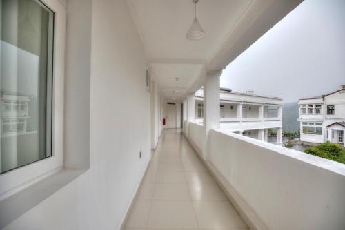 an empty corridor of a white building with a window at Rose Hill Bungalow in Gampola