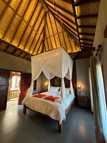 a bedroom with a canopy bed in a room at Munay Villa in Ubud