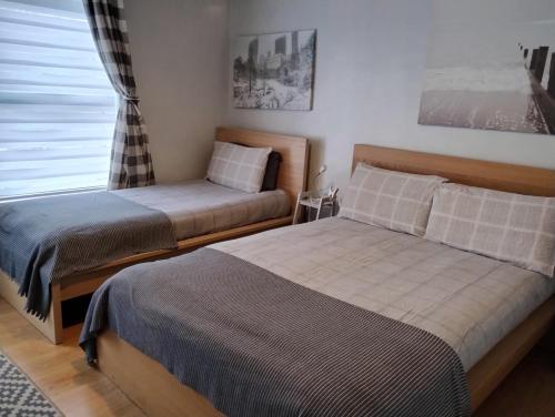 ベルファストにあるVery Central Location- Free Parking - 2 Bedroomsのベッド2台と窓のある寝室