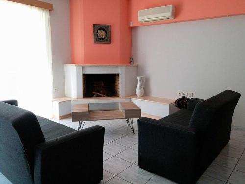 a living room with two chairs and a fireplace at Daphnus Apartment in Agios Konstantinos in Agios Konstantinos Fthiotida