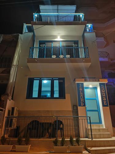 a building with a staircase and a balcony at night at Island House Kavala in Kavála