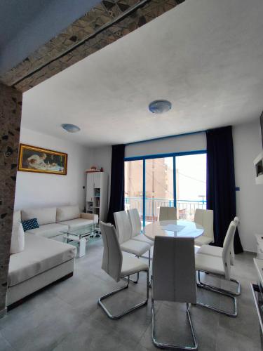 a living room with a couch and a table and chairs at Island House Kavala in Kavála