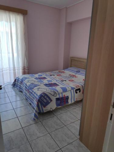 a bedroom with a bed and a tiled floor at Daphnus Apartment in Agios Konstantinos in Agios Konstantinos Fthiotida