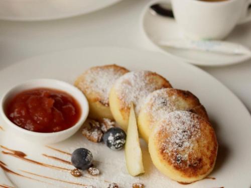 a plate of food with powdered sugar and blueberry jam at Kolochava Eco Resort in Kolochava